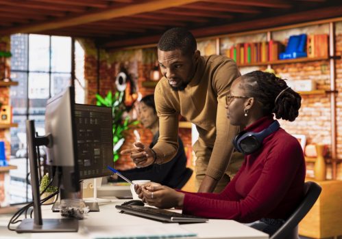 Teamworking startups employees leveraging machine learning technology in office to gain competitive edge. Silicon Valley company colleagues collaborating to do rapid technological advancement